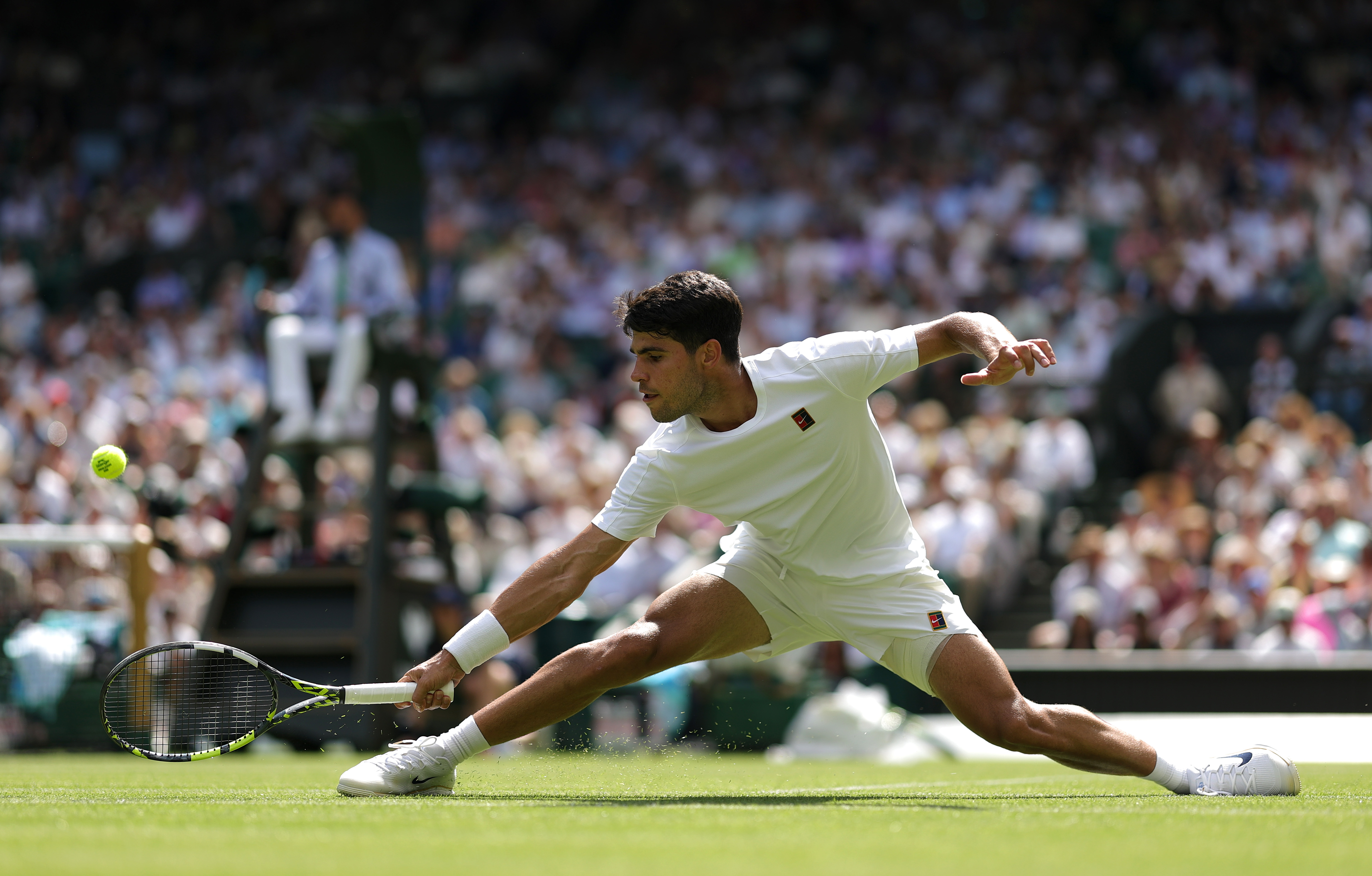 Carlos Alcaraz of Spain plays a backhand to Fabio Fognini of Italy during the Gentlemen's Singles first round match on day one of The Championships Wimbledon