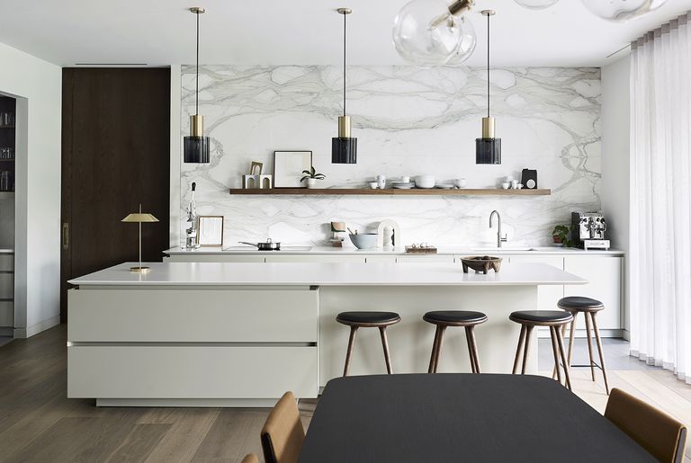 How to make a white kitchen look warm with marble backsplash and textured cabinets on a kitchen island