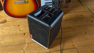 A Positive Grid Spark Edge guitar amp on a wooden floor