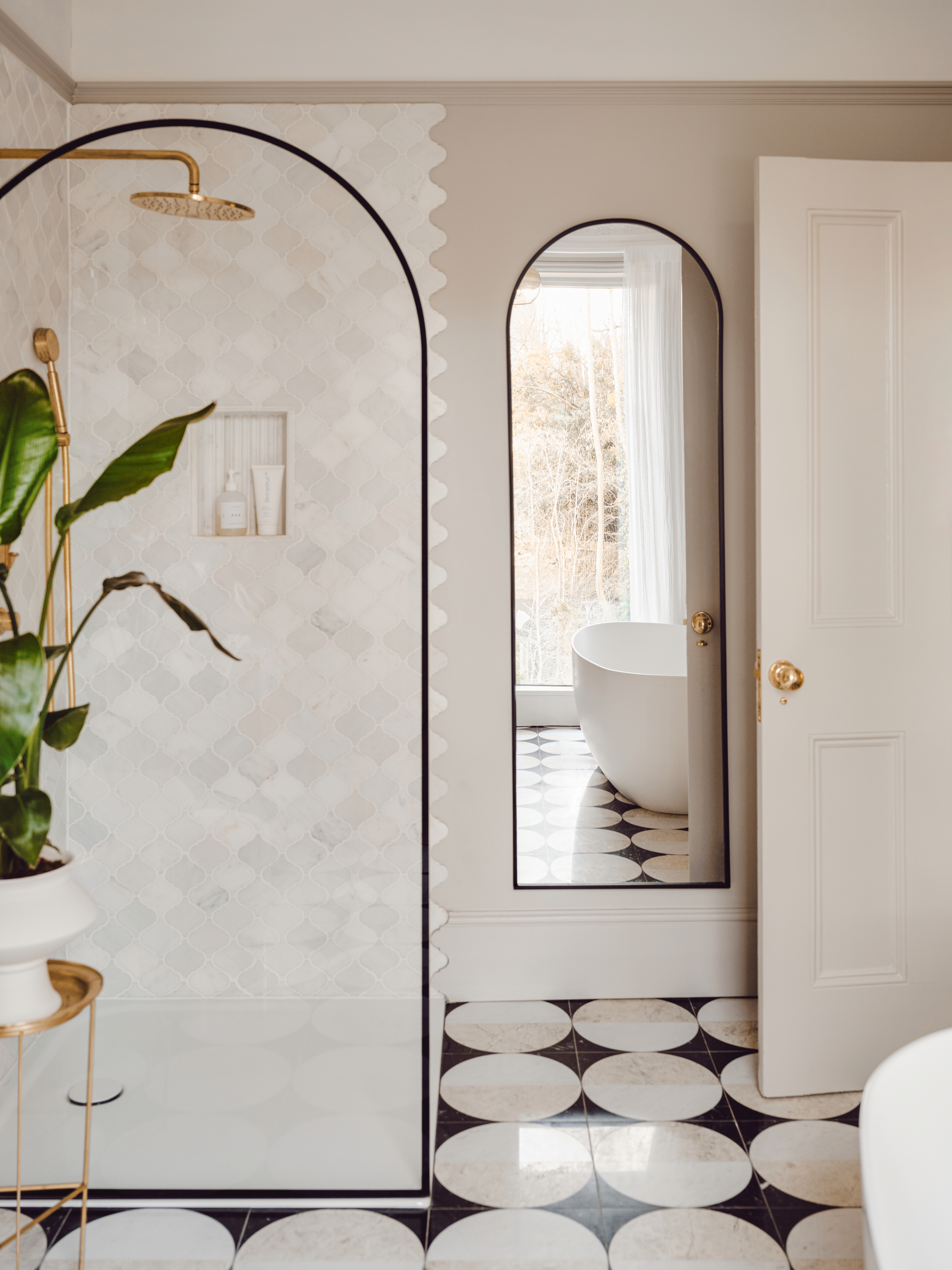 White bathroom with arched shower screen and mirror