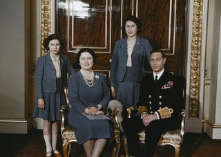 Queen Elizabeth II and her sister Princess Margaret pose for a family portrait with their parents Queen Elizabeth (Queen Mother) and King George VI at Buckingham Palace in May 1942.