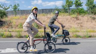 Two people aboard some of the best folding electric bikes, the Brompton Electric C Line