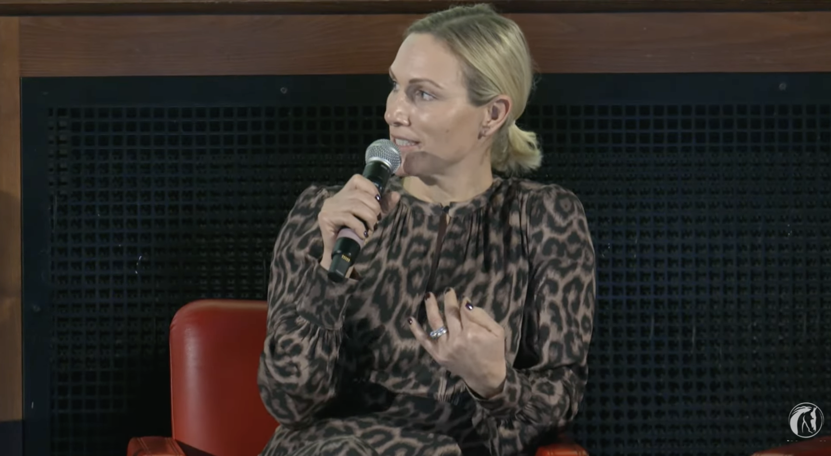 Zara Tindall wearing a leopard dress speaking on stage