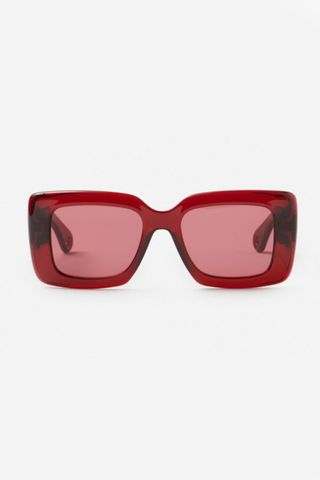 An image of the twist sunglasses from Lanvin, a chunky pair of sunlasses in a bold but refined red colour and twisted side panelling on the arms