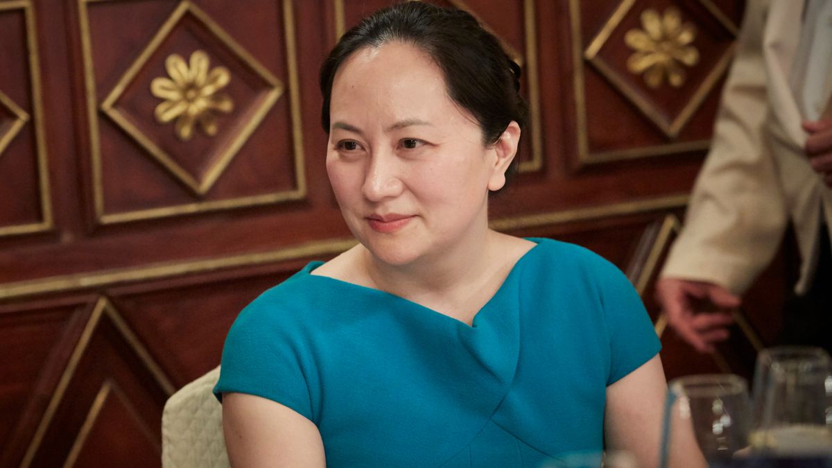 Meng Wanzhou in blue dress sitting at a table at conference in Milan in May 2018