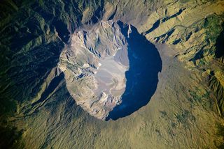 This detailed astronaut photograph depicts the summit caldera of the Tambora volcano. The volcano last erupted almost 200 years ago.
