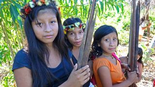Young women from the Awa Indigenous group in Brazil return from a hunt with their bows and arrows.