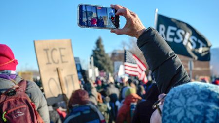 a person recording a video on their phone during a protest