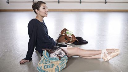 Woman Sitting on Floor in Ballet Shoes