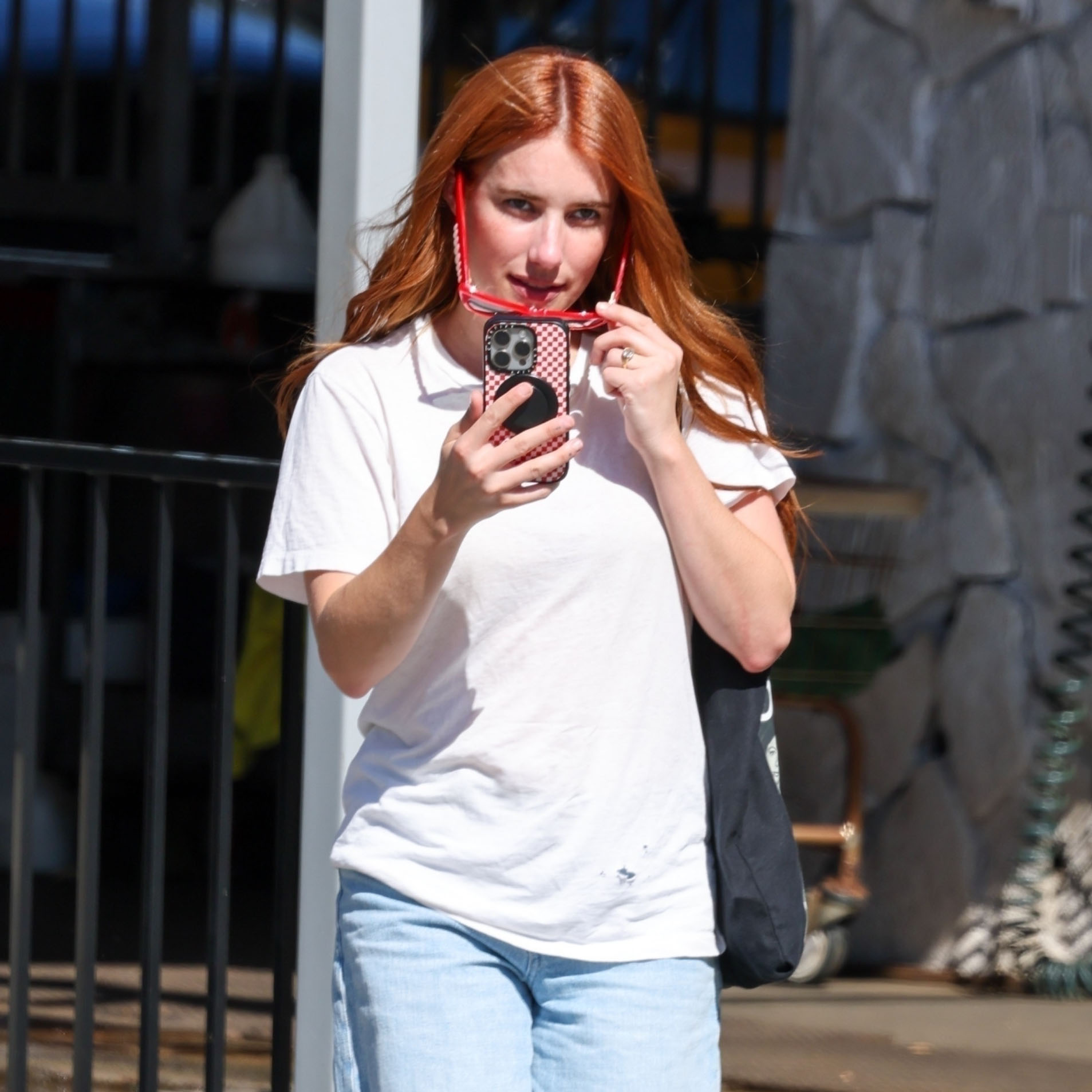 Emma Roberts wearing a plain white T-shirt and ripped, baggy blue jeans