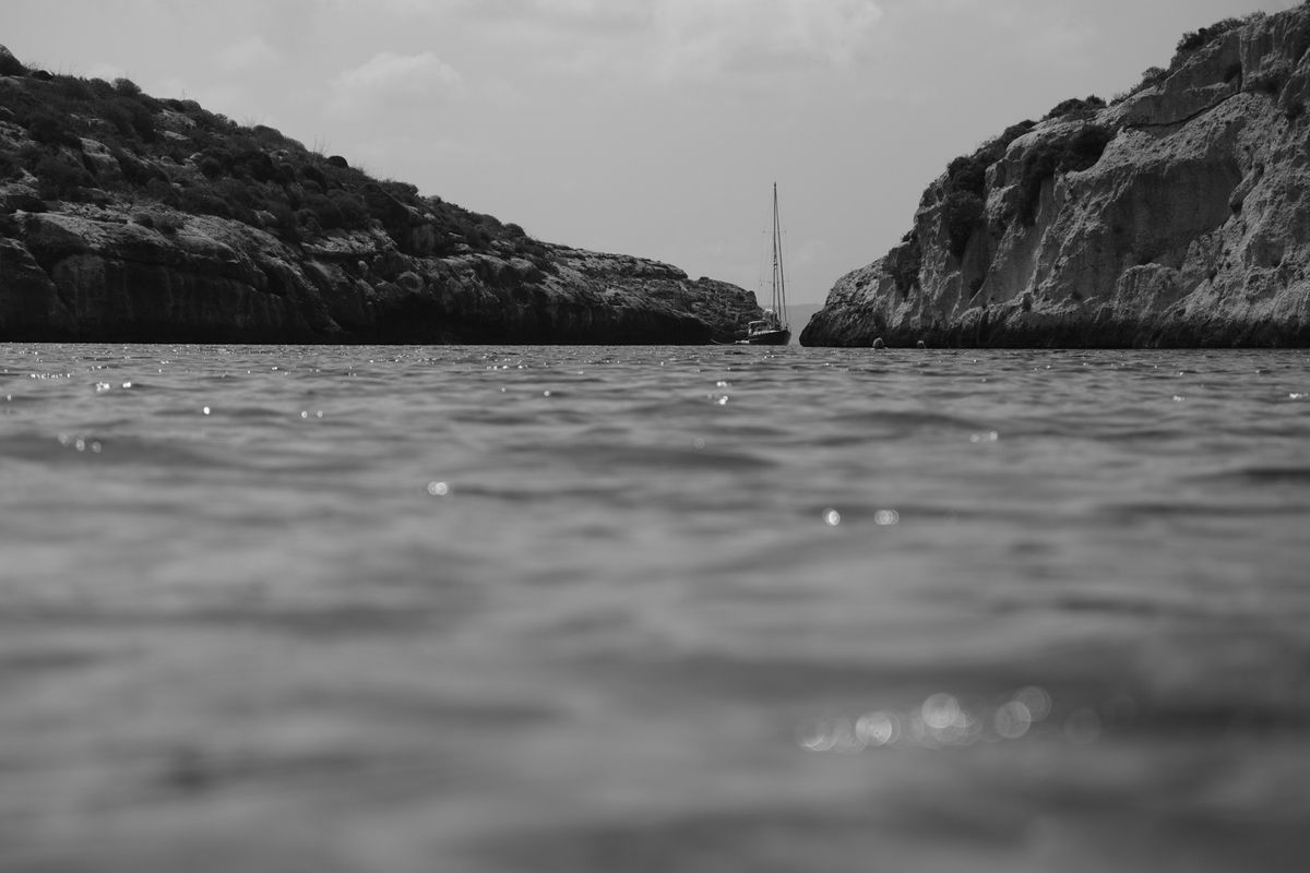 Black and white, Boat and rolling hills from sea-level perspective