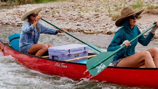 Two women canoeing with Yeti cooler