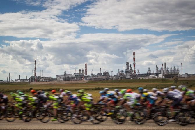The peloton passes by a large chemical plant along the route