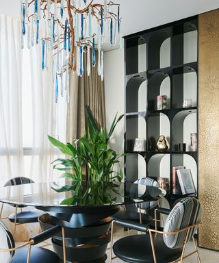 retro small dining room with glass circular table and black wall shelves