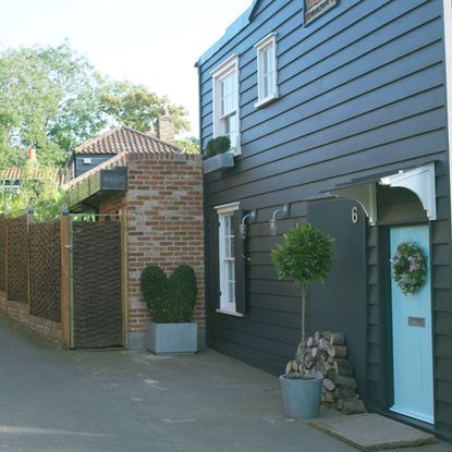 house exterior with dark blue wall white window and blue door