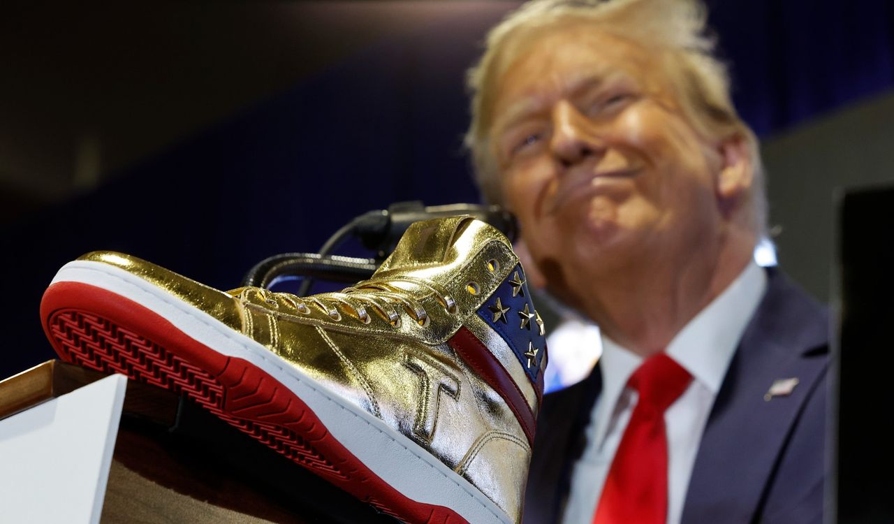 Donald Trump poses with branded gold sneakers