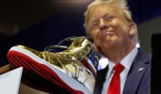 Donald Trump poses with branded gold sneakers