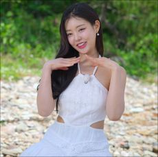 a woman in a white dress poses outdoors during single's inferno season 3