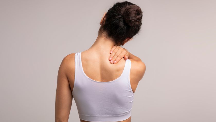 the back of a woman stretching her shoulder