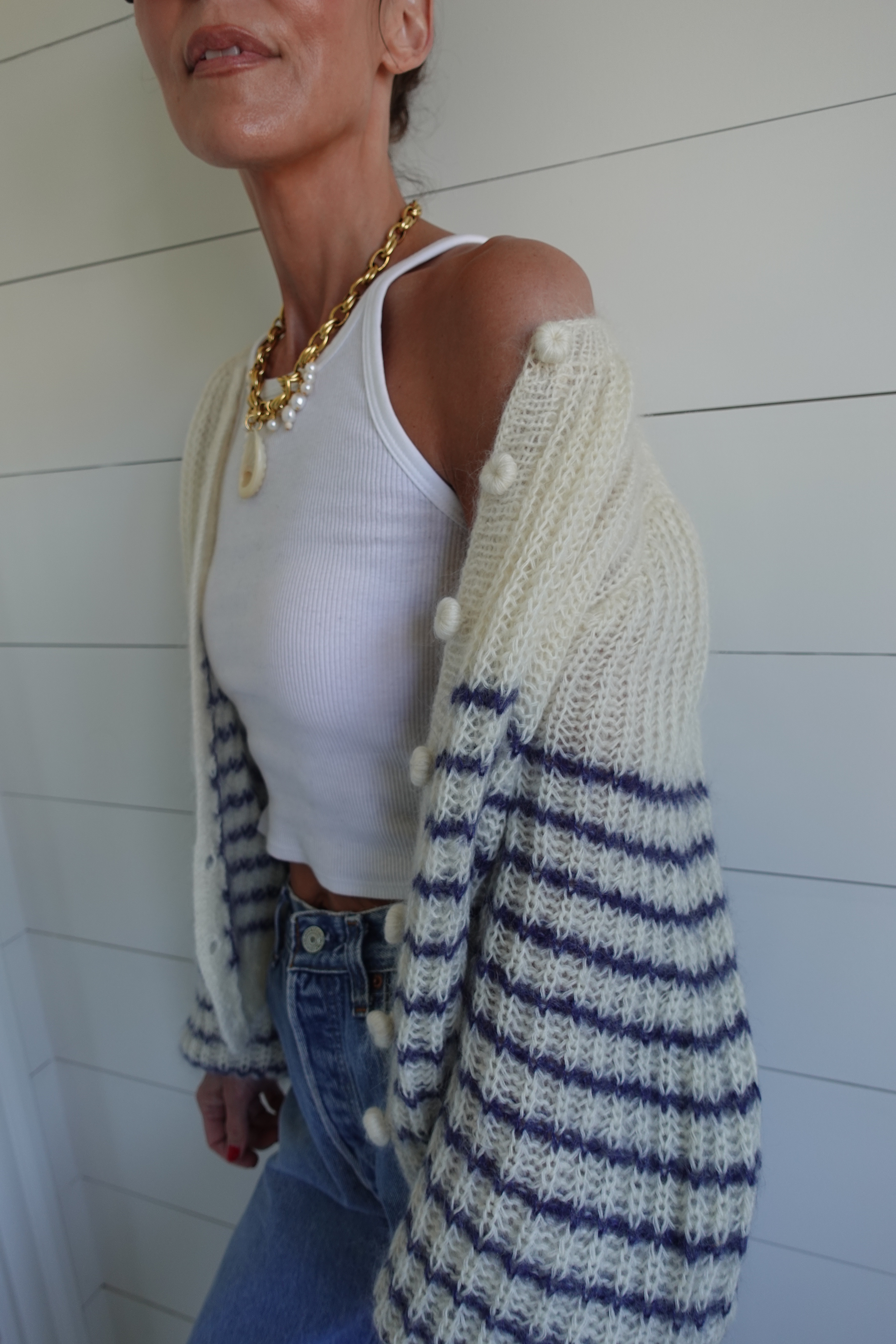 Larissa Mills wearing a white tank top and blue jeans outfit