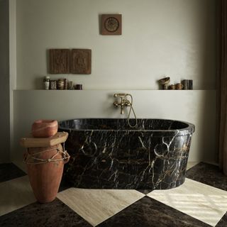 dark marble freestanding bath with checkered floor