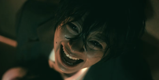 A woman laughs hysterically in this creepy shot from Ju-On: Origins