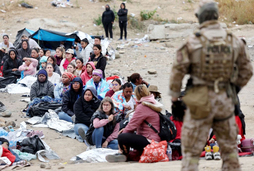 A Border Patrol agent watches migrants on the U.S.-Mexico border. 