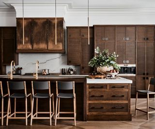 Wooden cabinets, black high chairs, gold taps