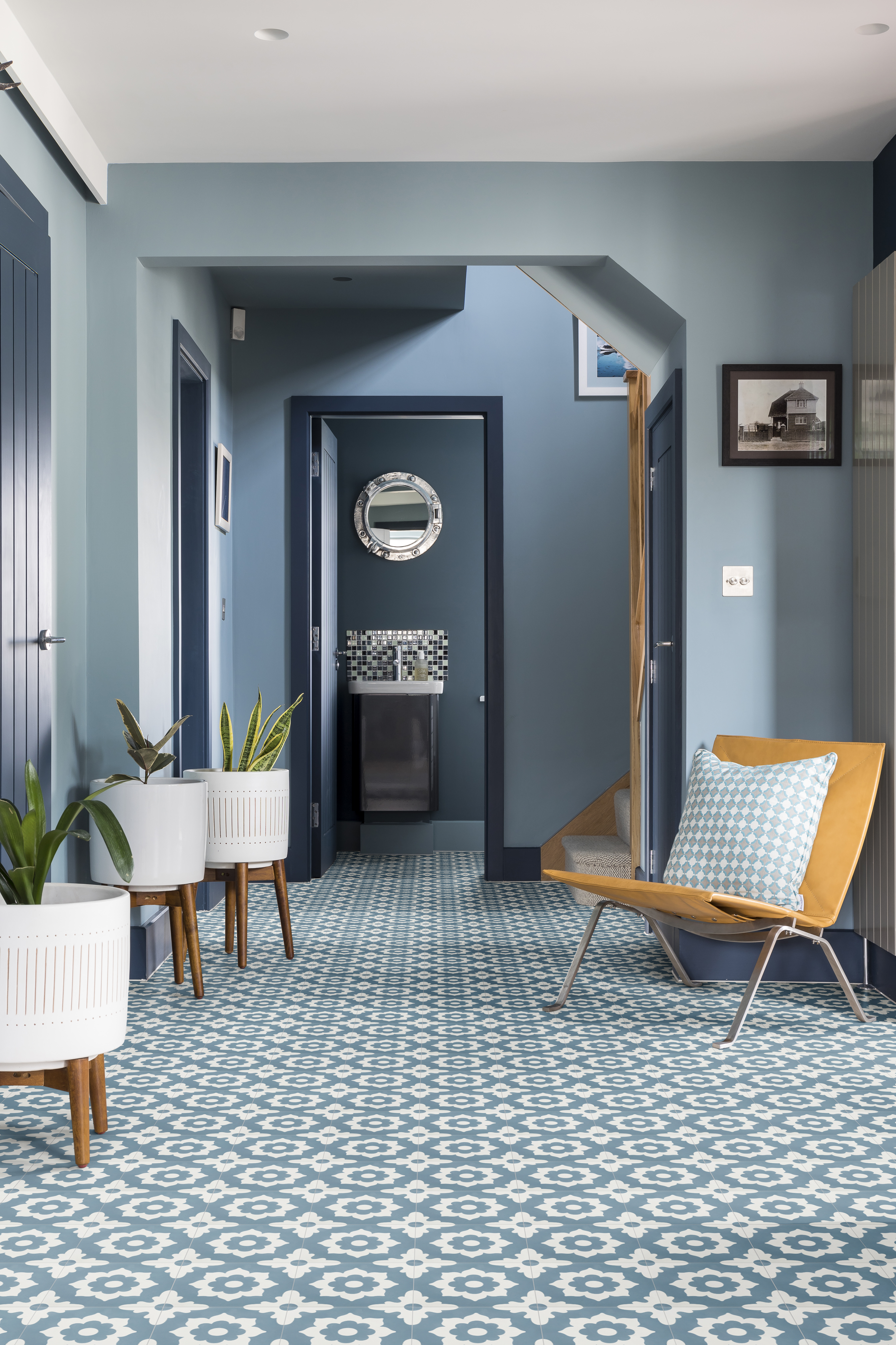 Blue hallways with geometric tiles and yellow statement chair
