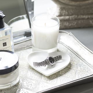white scented candle on tray