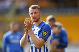 Adam Webster applauds the travelling Brighton fans after a game against Wolves in August 2023.