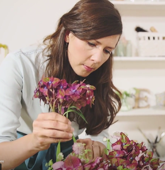 women placing flowers in vase