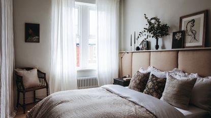 White painted bedroom with large windows, long white curtains, bed