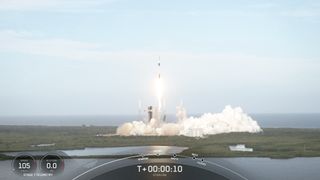 a black-and-white spacex falcon 9 rocket launches into a blue sky.