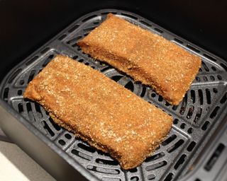 Two salmon filets cooked in the Cosori Premium II Plus 6.5 quart air fryer (basket view)