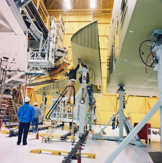 The right wing is being installed onto the mid-fuselage at the Rockwell Palmdale facility, Calif., on February 19, 1988.