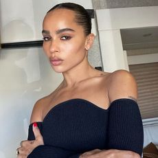 Zoe Kravitz taking a selfie wearing a slicked-back bun 