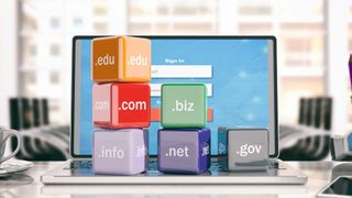 Domain names cubes on a laptop - office background