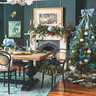 Dining room covered in christmas decorations, including a christmas tablescape and a christmas tree in the corner