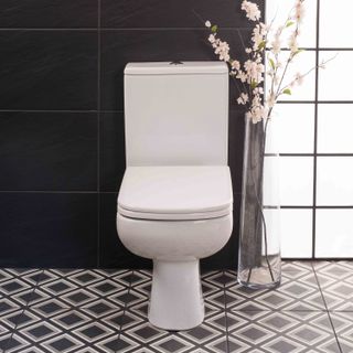 close coupled toilet in white from Bathroom Takeaway in a bathroom with patterned tile floor