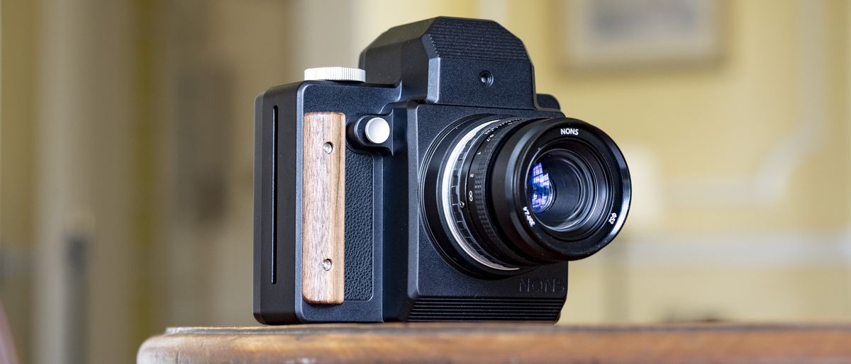 Nons SL660 instant camera on a mahogany table