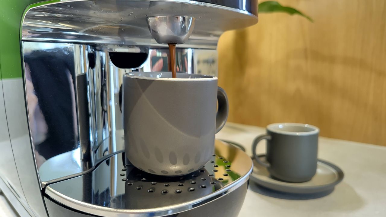 Lavazza A Modo Mio Smeg coffee maker dispensing espresso into cup