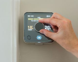 female hand adjusting a thermostat