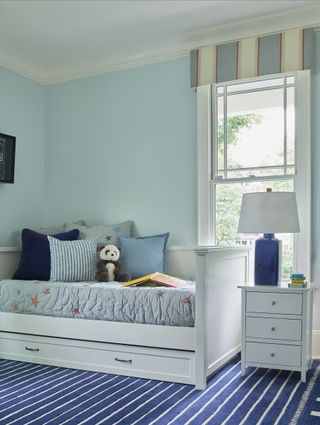 boys bedroom with blue striped carpet, blue walls and starred bed linen