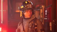 Oliver Stark as Buck dressed in his firefighter uniform looking serious in Season 10, Episode 3 of 9-1-1