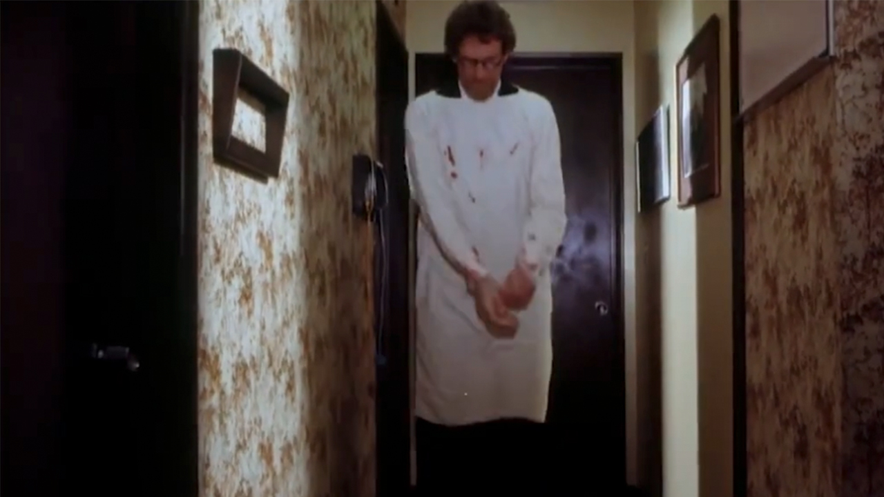 A man in a white smock walking down a hallway in Faces of Death