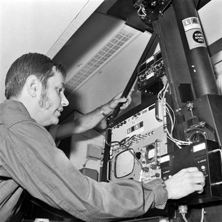 a person inspects equipment while wearing a long sleeved shirt.