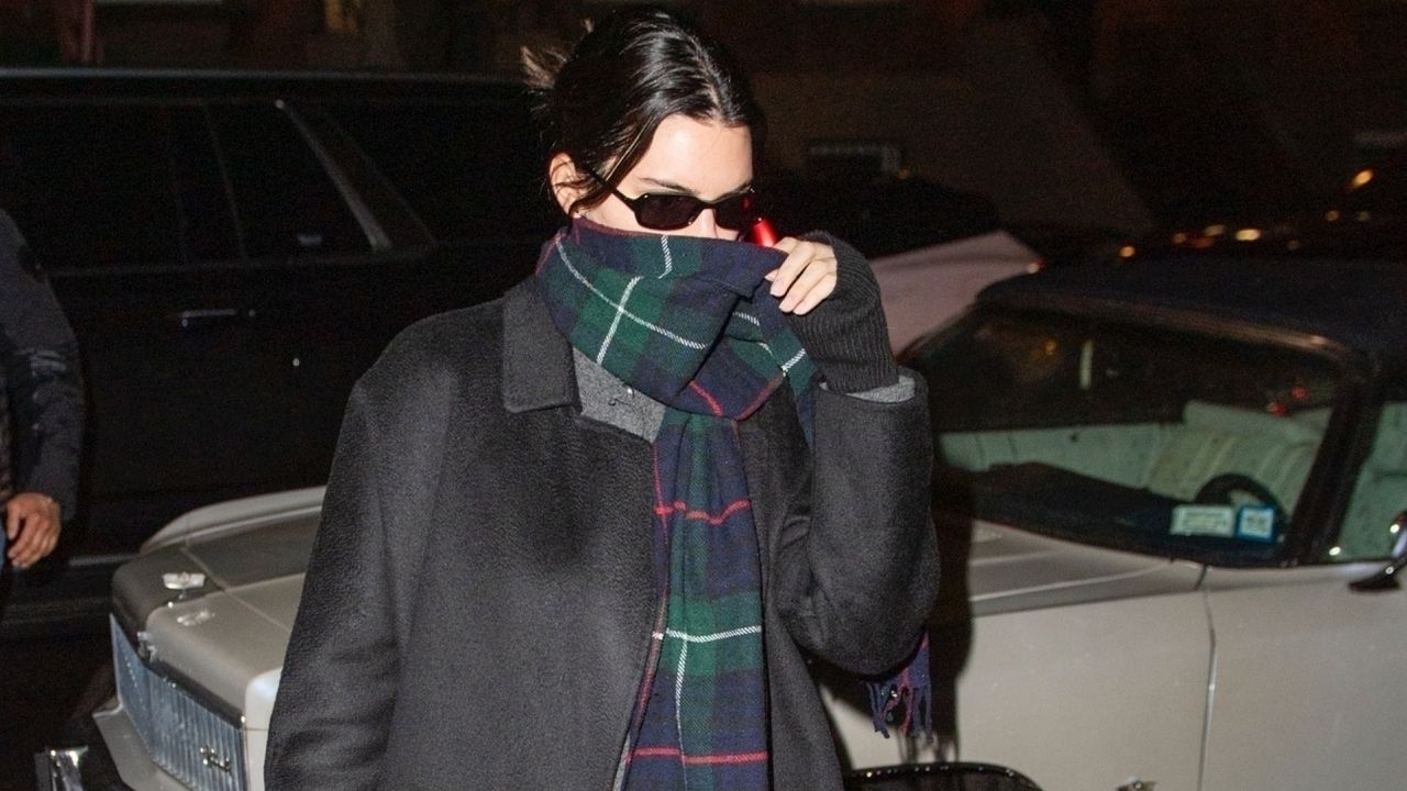 Kendall Jenner wearing a gray coat and plaid scarf