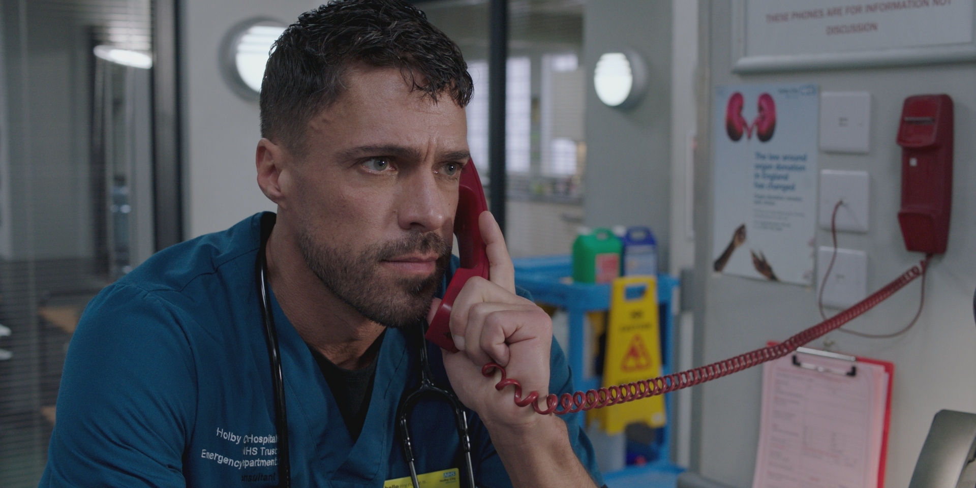 Flynn looks tense as he talks on the ED's red telephone for emergency situations.