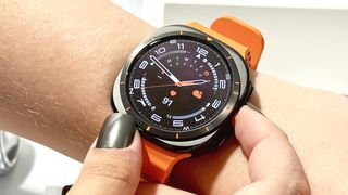The Samsung Galaxy Watch Ultra on an orange rubber strap worn on the wrist of a user